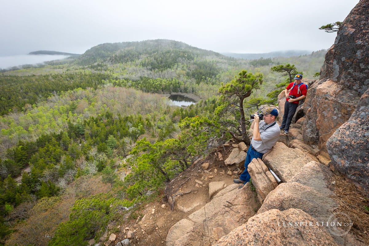 Photographers climb the Beehive at Acadia National Park in Maine as clouds roll in over landscape