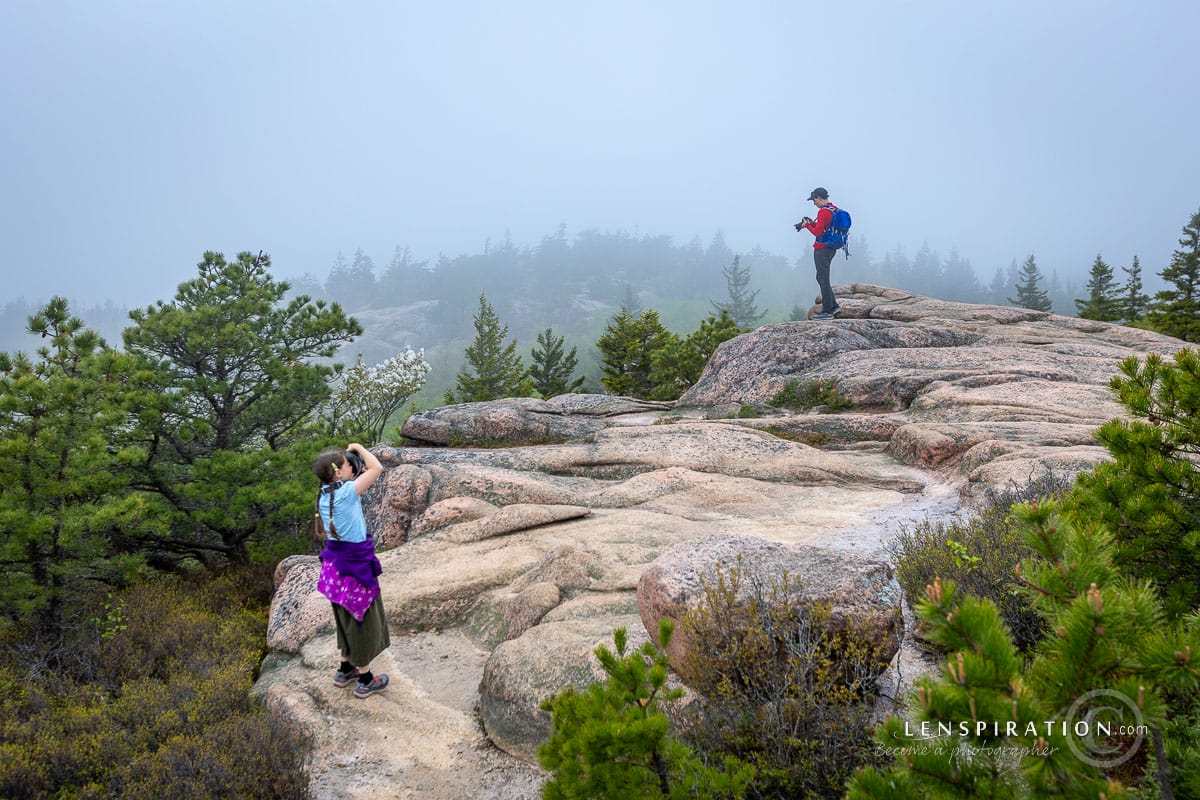 Student photographers take pictures at Acadia National Park in Maine as clouds cover the landscape