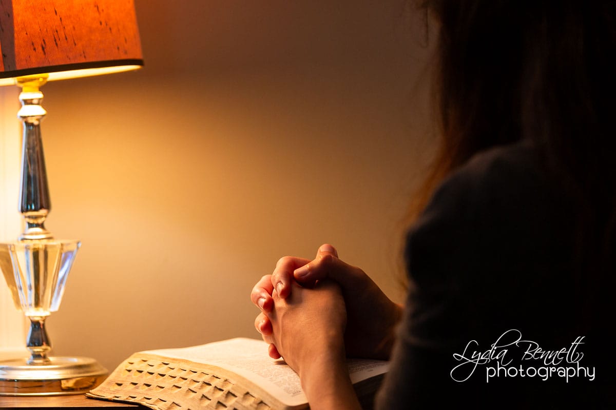 Cozy prayer time with woman praying over Bible