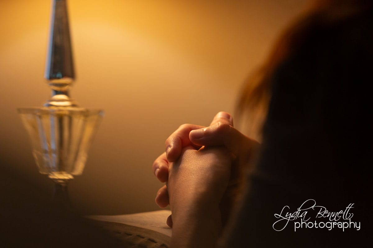 Woman's hands folded in prayer at Bible time