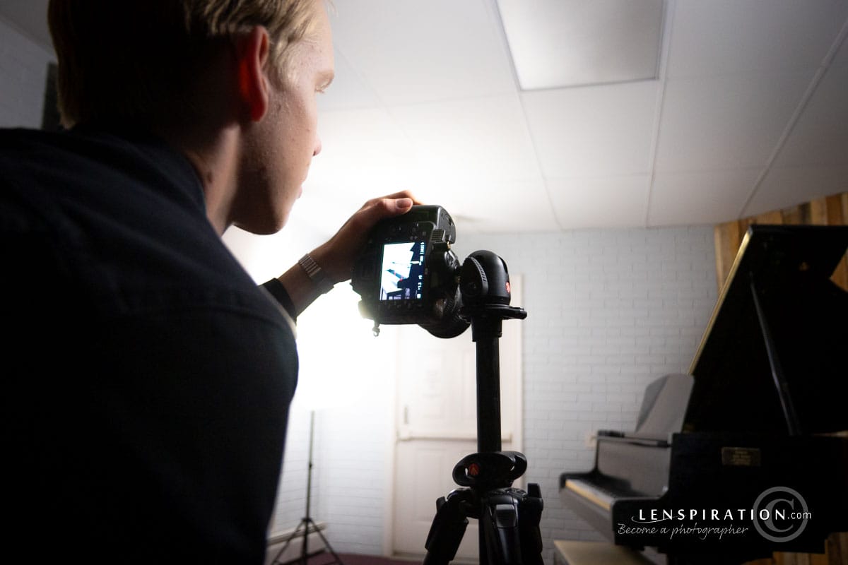 Preparing for a photography shoot at a piano under studio lighting